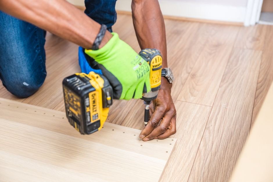 Perceuse visseuse utilisée pour assembler l'ossature en bois d'un cache poubelle extérieur