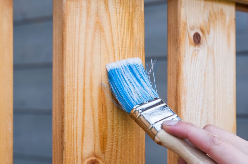 Application au pinceau d'une lasure de protection sur une planche de bois extérieur