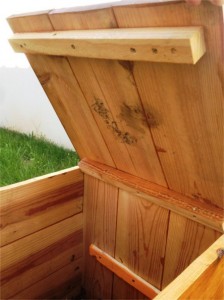 Intérieur d'un composteur en bois montré avec le couvercle ouvert