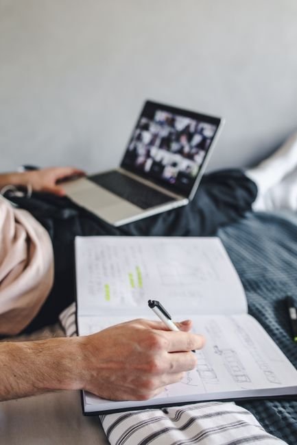 Personne prenant des notes pendant un cours en ligne sur ordinateur portable