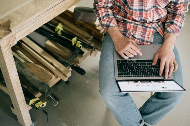 Un bricoleur consulte un ordinateur portable dans son atelier