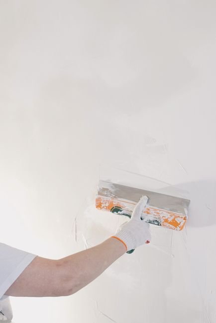 Application d'enduit à la spatule sur un mur