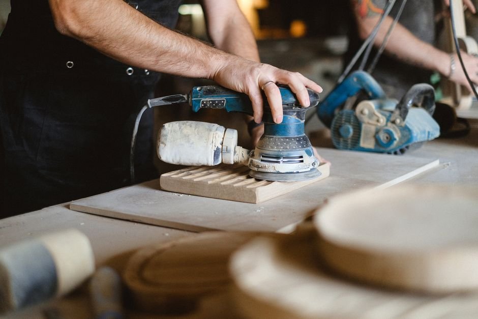 Ponceuse électrique utilisée sur du bois en atelier