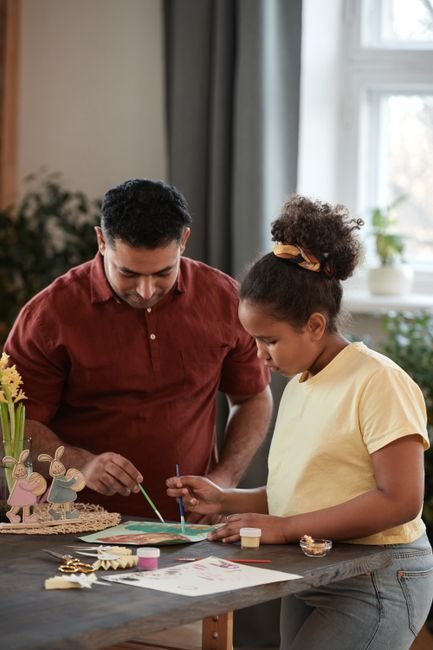 Un père et son enfant fabriquent ensemble un cadeau fait main