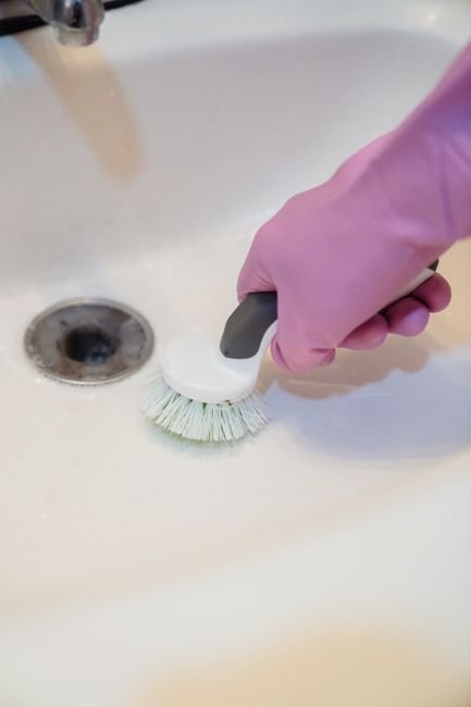 Main gantée nettoyant à la brosse