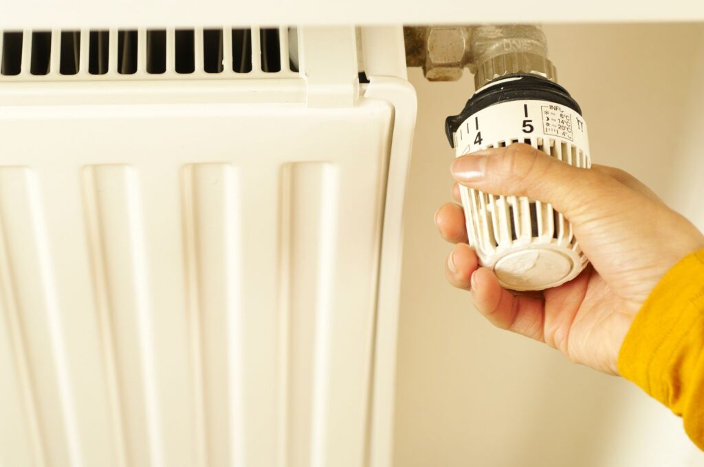 Main réglant un robinet thermostatique de radiateur