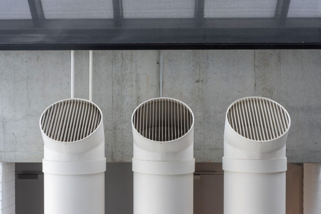 Gaines de ventilation blanches contre un mur