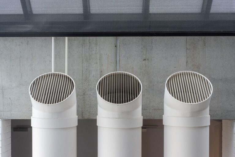 Gaines de ventilation blanches contre un mur