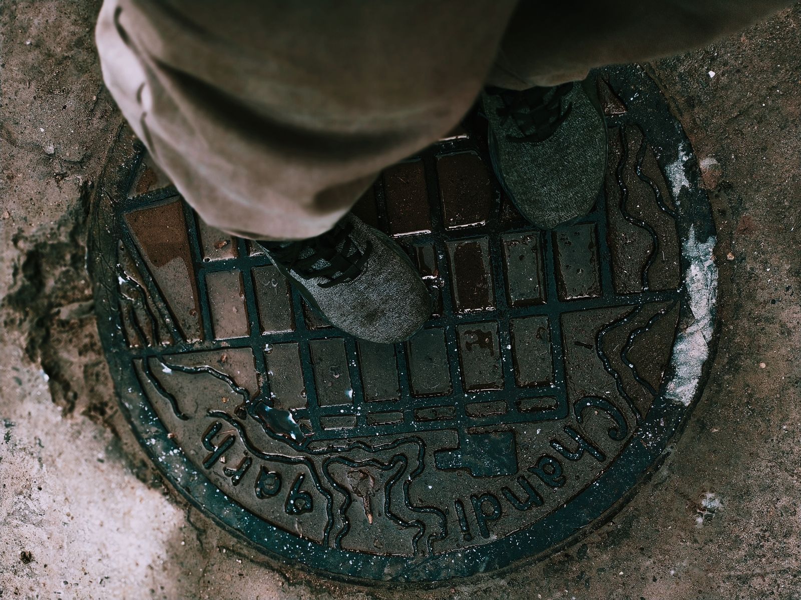 Personne debout sur une plaque de regard métallique