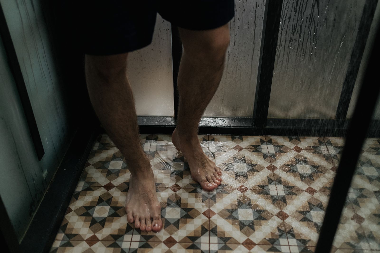 Eau qui ruisselle sur le sol d'une douche carrelée